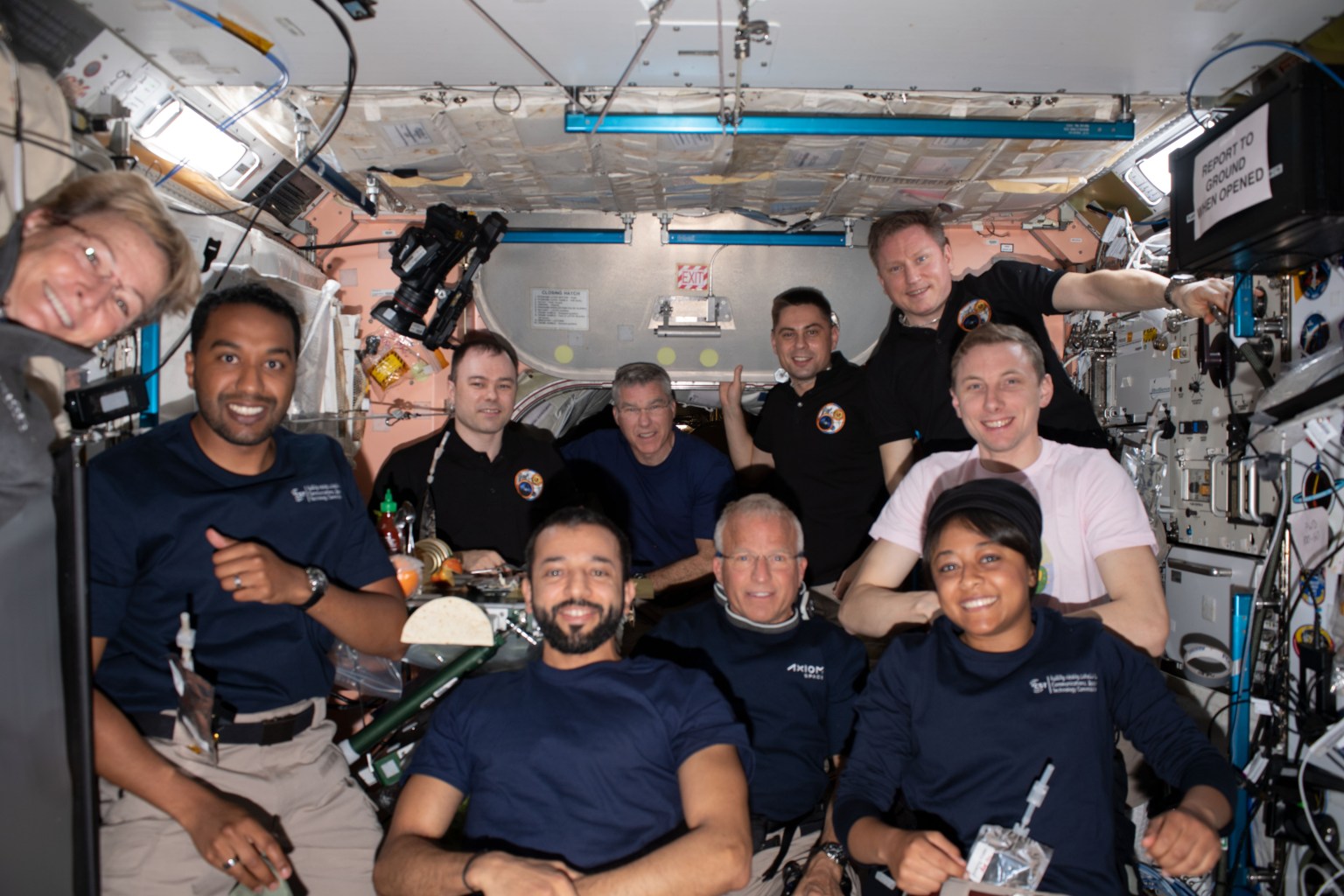 The Axiom Mission-2 and Expedition 69 crew members pose for a portrait together during dinner time aboard the International Space Station. In the center front row, is Expedition 69 crew member and UAE (United Arab Emirates) astronaut Sultan Alneyadi flanked by (from left) Axiom Mission-2 crew members Commander Peggy Whitson, Mission Specialist Ali Alqarni, Pilot John Shoffner, and Mission Specialist Rayyanah Barnawi. In the back (from left) are, Expedition 69 crew members Roscosmos cosmonaut Dmitri Petelin, NASA astronaut Stephen Bowen, Roscosmos cosmonauts Andrey Fedyaev and Sergey Prokopyev, and NASA astronaut Woody Hoburg. Not pictured is NASA astronaut Frank Rubio.