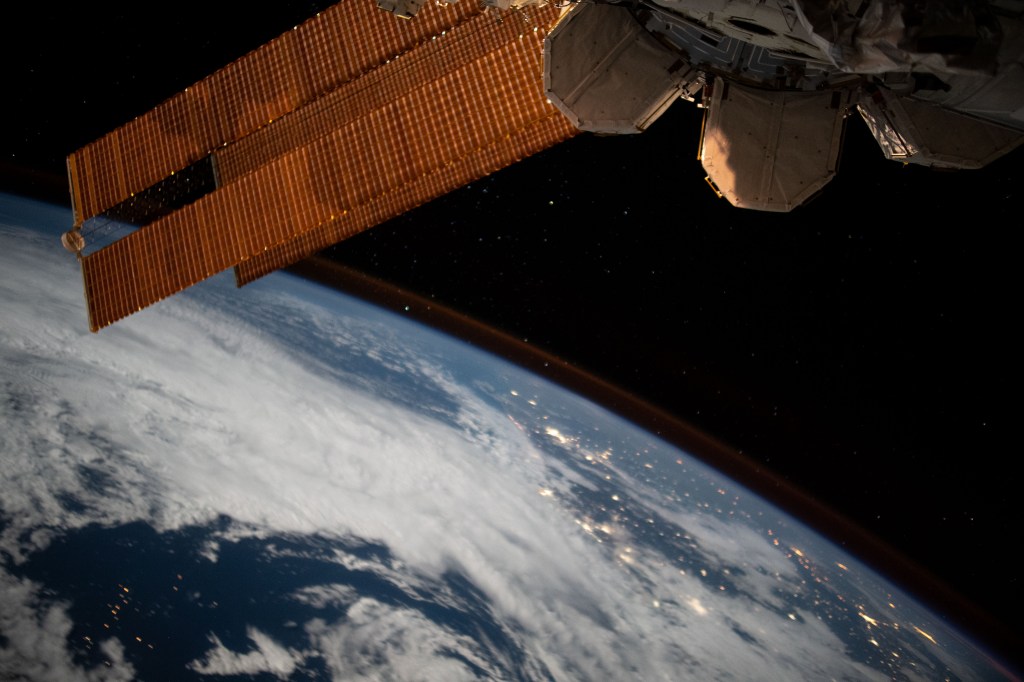 The city lights of Brazil sparkle underneath cloudy skies and a dim atmospheric glow as the International Space Station orbited 263 miles above the Atlantic Ocean off the coast of the South American nation.