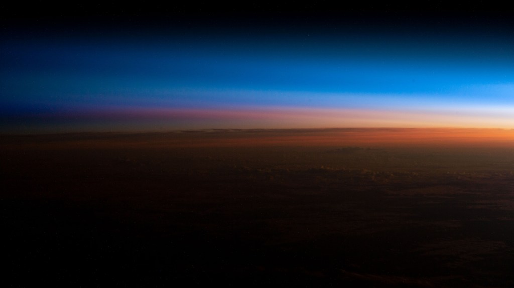 iss068e051124 (Feb. 10, 2023) --- An orbital sunrise begins illuminating Earth's atmosphere and revealing the cloud tops in this photograph from the International Space Station as it orbited 260 miles above southern Brazil.