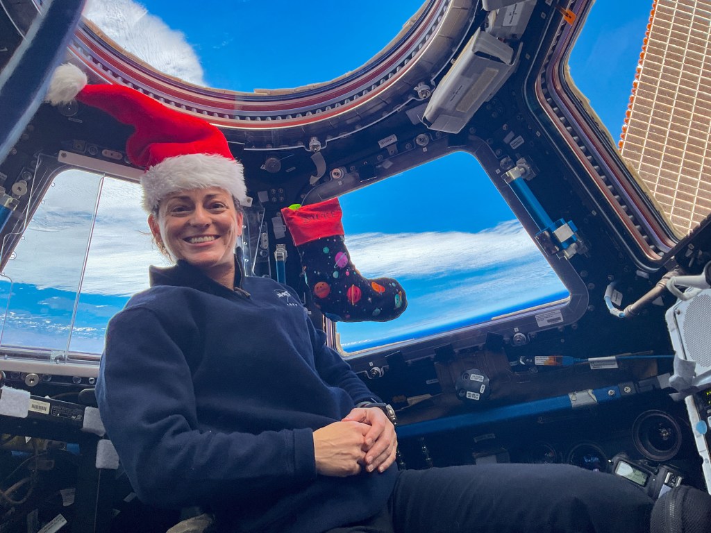 iss068e032470 (Dec. 24, 2022) --- Expedition 68 Flight Engineer Nicole Mann of NASA poses for a festive portrait on Christmas Eve inside the cupola as the International Space Station orbited 268 miles above the Pacific Ocean off the coast of southern Chile.