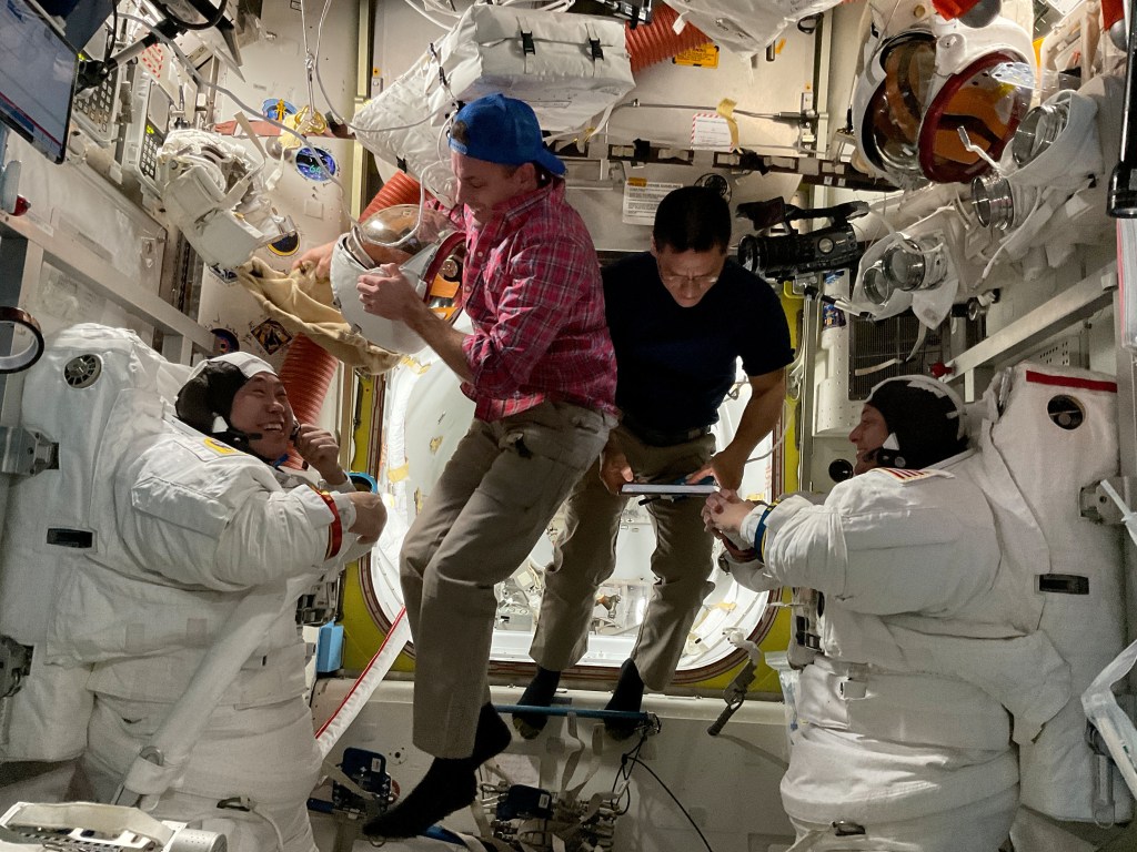 iss068e054809 (Feb. 2, 2023) --- (At far left and right) Astronauts Koichi Wakata of JAXA (Japan Aerospace Exploration Agency) and Nicole Mann of NASA are suited up in their Extravehicular Mobility Units (EMUs), or spacesuits, following a spacewalk on Feb. 2, 2023, to install hardware on the International Space Station's Port-6 truss structure. Assisting the duo out of their EMUs are NASA Flight Engineers (center left and right) Josh Cassada and Frank Rubio.