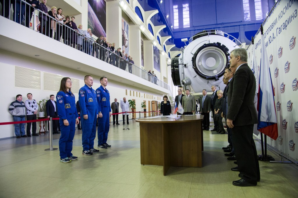 At the Gagarin Cosmonaut Training Center in Star City, Russia, Expedition 59 crew members Christina Koch of NASA (left), Alexey Ovchinin of Roscosmos (center) and Nick Hague of NASA (right) report to Russian space officials Feb. 19 during the first of two days of final pre-launch qualification exams. They will launch March 14, U.S. time, from the Baikonur Cosmodrome in Kazakhstan on the Soyuz MS-12 spacecraft for a six-and-a-half month mission on the International Space Station.
