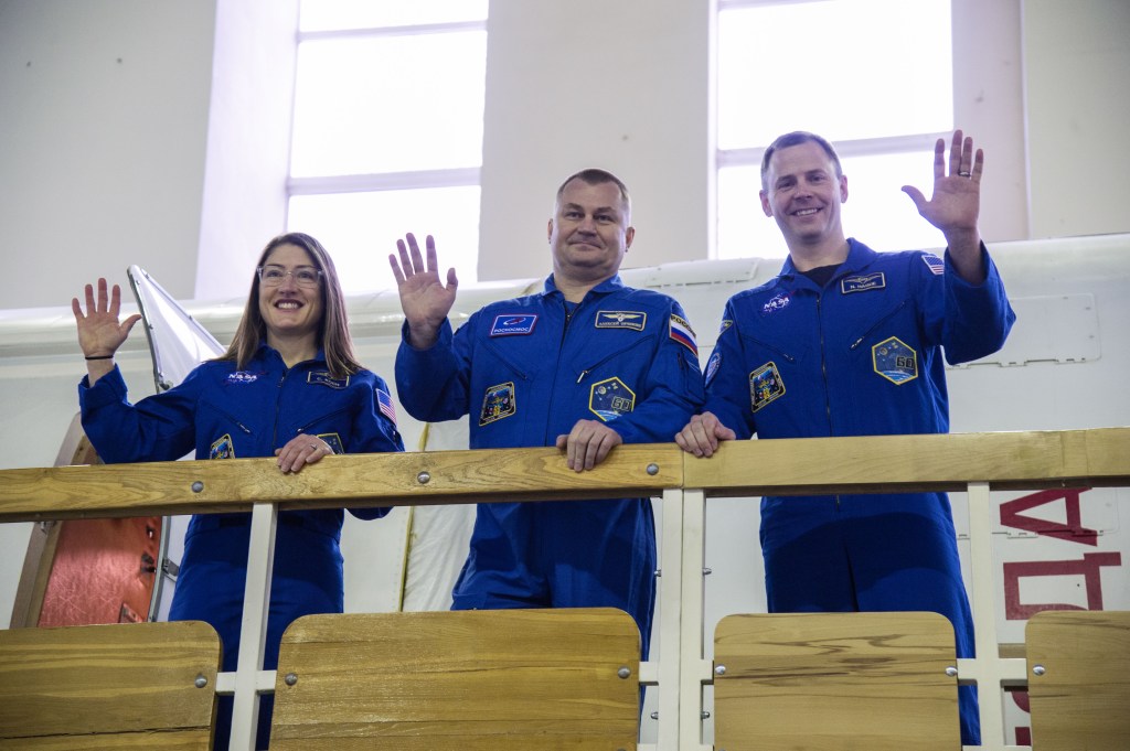 At the Gagarin Cosmonaut Training Center in Star City, Russia, Expedition 59 crew members Christina Koch of NASA (left), Alexey Ovchinin of Roscosmos (center) and Nick Hague of NASA (right) wave to cameras Feb. 19 during the first of two days of final pre-launch qualification exams. They will launch March 14, U.S. time, from the Baikonur Cosmodrome in Kazakhstan on the Soyuz MS-12 spacecraft for a six-and-a-half month mission on the International Space Station.