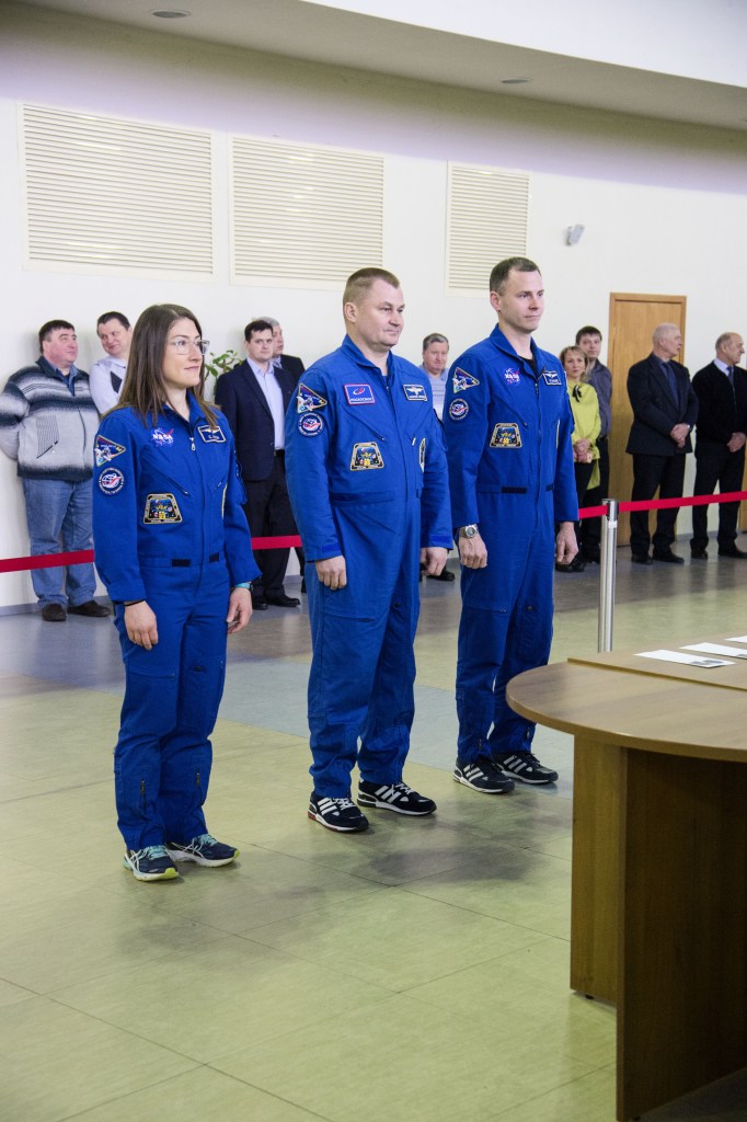 At the Gagarin Cosmonaut Training Center in Star City, Russia, Expedition 59 crew members Christina Koch of NASA (left), Alexey Ovchinin of Roscosmos (center) and Nick Hague of NASA (right) report to Russian space officials Feb. 19 during the first of two days of final pre-launch qualification exams. They will launch March 14, U.S. time, from the Baikonur Cosmodrome in Kazakhstan on the Soyuz MS-12 spacecraft for a six-and-a-half month mission on the International Space Station.