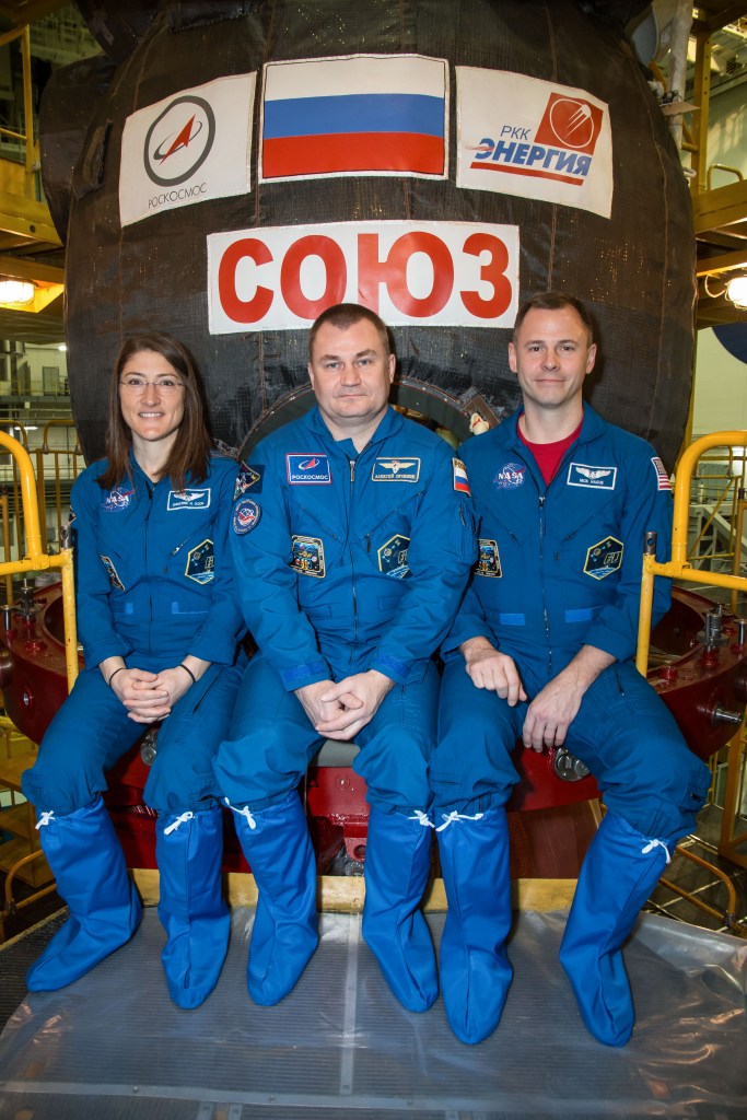 At the Baikonur Cosmodrome in Kazakhstan, Expedition 59 crew members Christina Koch of NASA (left), Alexey Ovchinin of Roscosmos (center) and Nick Hague of NASA (right) pose for pictures in front of their Soyuz MS-12 spacecraft Feb. 27 during pre-launch training. They will launch March 14, U.S. time, on the Soyuz MS-12 spacecraft from the Baikonur Cosmodrome in Kazakhstan for a six-and-a-half month mission on the International Space Station.