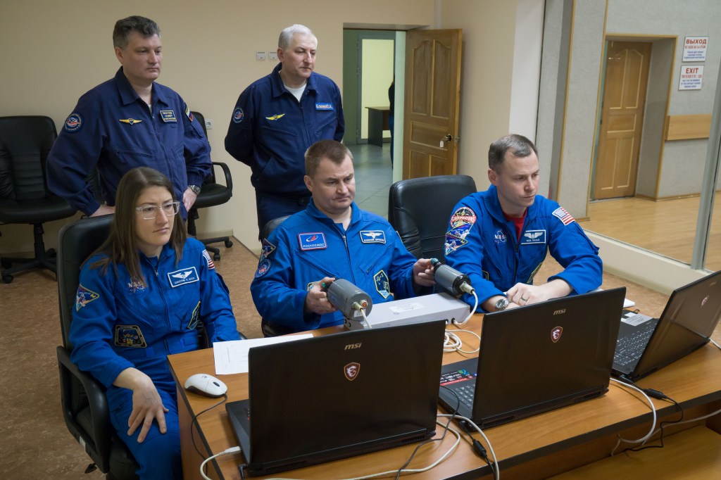 At their Cosmonaut Hotel crew quarters in Baikonur, Kazakhstan, Expedition 59 crew members Christina Koch of NASA (left), Alexey Ovchinin of Roscosmos (center) and Nick Hague of NASA (right) rehearse rendezvous and docking techniques on a laptop computer simulator March 7 as they prepare for launch. They will launch March 14, U.S. time, on the Soyuz MS-12 spacecraft from the Baikonur Cosmodrome for a six-and-a-half month mission on the International Space Station.