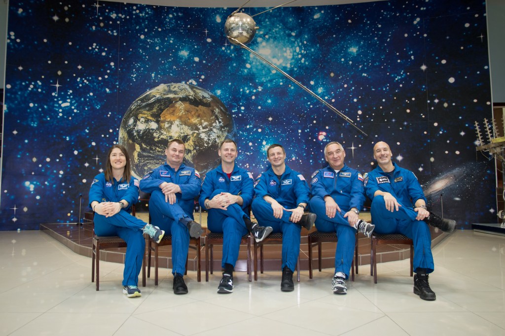 At the Baikonur Cosmodrome Museum in Kazakhstan, a model of the world’s first satellite, Sputnik, serves as a hanging backdrop March 10 as the Expedition 59 prime and backup crewmembers pose for pictures in traditional pre-launch activities. From left to right are the prime crew members, Christina Koch of NASA, Alexey Ovchinin of Roscosmos and Nick Hague of NASA, and the backup crew members, Drew Morgan of NASA, Alexander Skvortsov of Roscosmos and Luca Parmitano of the European Space Agency. Koch, Hague and Ovchinin will launch March 14, U.S. time, in the Soyuz MS-12 spacecraft from the Baikonur Cosmodrome for a six-and-a-half month mission on the International Space Station.