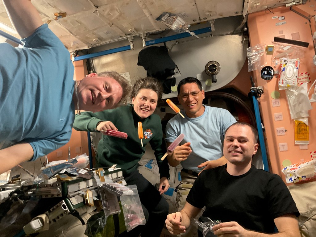 iss068e054799 (Dec. 28, 2022) --- Four Expedition 68 crewmates join each other for a meal inside the International Space Station's Harmony module. From left are, Commander Sergey Prokopyev and Flight Engineer Anna Kikina, both from Roscosmos, NASA Flight Engineer Frank Rubio, and Roscosmos Flight Engineer Dmitri Petelin.