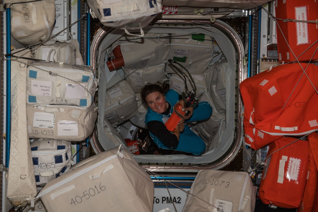 iss068e020521 (Nov. 3, 2022) --- Roscosmos cosmonaut and Expedition 68 Flight Engineer Anna Kikina is pictured carrying personal protective equipment inside the Harmony module's forward-facing international docking adapter where the SpaceX Dragon Endeavour crew ship is docked.
