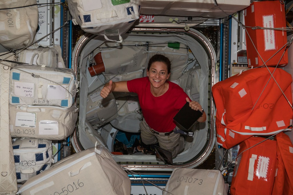 iss068e020519 (Nov. 3, 2022) --- NASA astronaut and Expedition 68 Flight Engineer Nicole Mann gives a "thumbs up" from inside the Harmony module's forward-facing international docking adapter where the SpaceX Dragon Endeavour crew ship is docked.