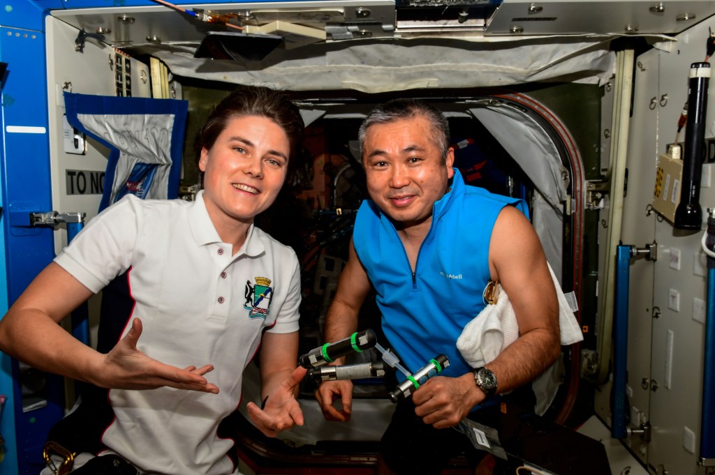 iss068e041017 (Jan. 19, 2023) --- Expedition 68 Flight Engineers Anna Kikina of Roscosmos and Koichi Wakata of the Japan Aerospace Exploration Agency (JAXA) pose together with dosimeters, or radiation detectors, floating weightlessly in the microgravity environment of the International Space Station. Credit: Roscosmos