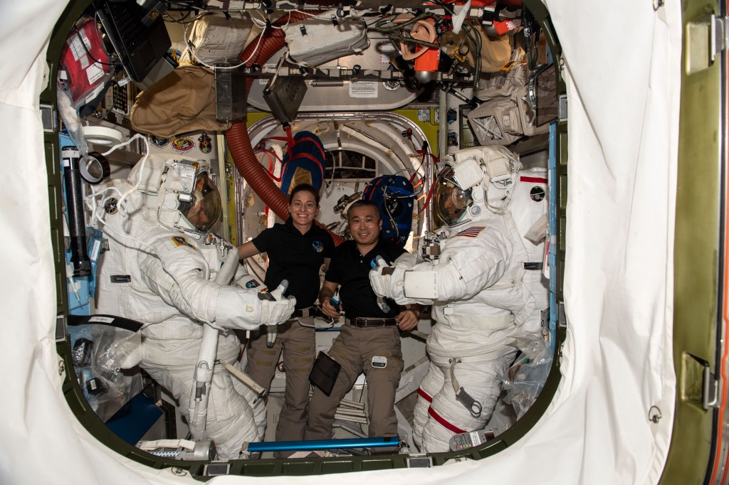 iss068e031353 (Dec. 21, 2022) --- Expedition 68 Flight Engineers Nicole Mann (center left) of NASA and Koichi Wakata (center right) of the Japan Aerospace Exploration Agency (JAXA) pose with NASA spacewalkers Frank Rubio (far left) and Josh Cassada (far right) who were suited up and ready to begin a spacewalk to install a roll-out solar array on the International Space Station's Port-4 truss segment. The spacewalk was ultimately postponed for 24 hours so that the orbiting lab’s ISS Progress 81 cargo craft could fire its engines to maneuver the station and avoid an approaching piece of rocket debris.