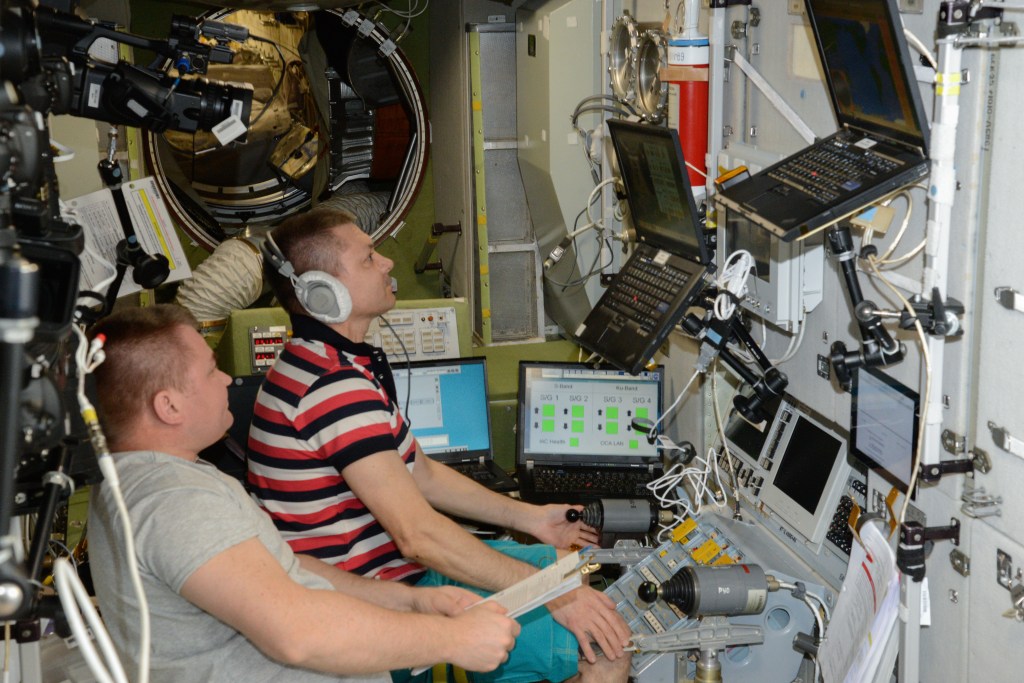 (From right) Flight Engineer Alexey Ovchinin and Commander Oleg Kononenko, both cosmonauts from Roscosmos, train for the arrival of the Russian Progress 72 (72P) resupply ship. The Expedition 59 duo inside the Zvezda service module practiced using the TORU, a backup manual docking system, to guide the 72P to a docking in the unlikely event the resupply ship’s automatic Kurs docking system failed.