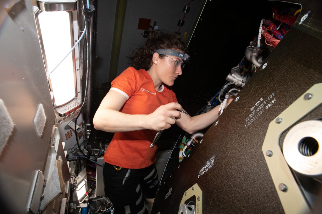 NASA astronaut and Expedition 59 Flight Engineer Christina Koch removes audio hardware from an avionics rack inside the Tranquility module.