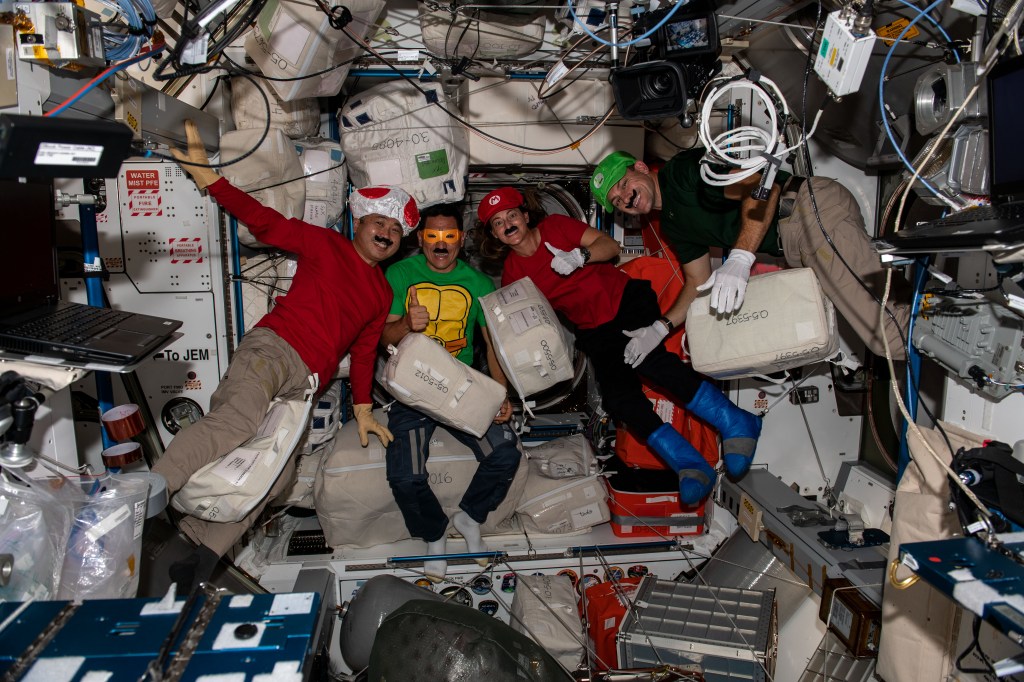 iss068e020276 (Oct. 31, 2022) --- Four Expedition 68 Flight Engineers dress up as popular video game and cartoon characters to celebrate Halloween fun aboard the International Space Station. From left are, Japan Aerospace Exploration Agency (JAXA) astronaut Koichi Wakata with NASA astronauts Frank Rubio, Nicole Mann, and Josh Cassada.