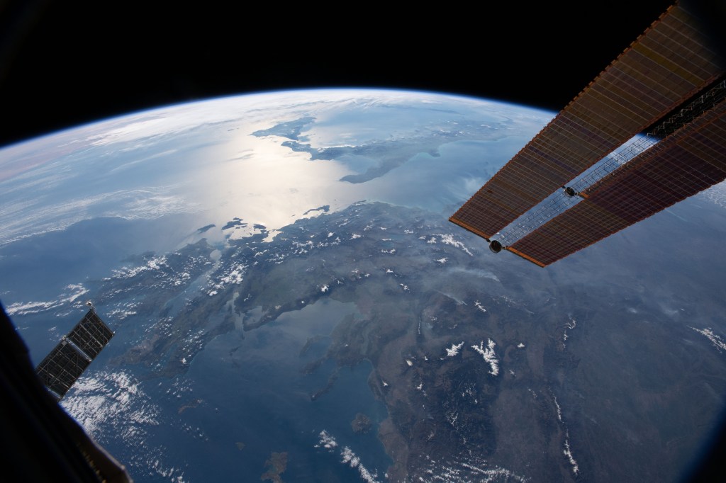 The International Space Station orbits 256 miles above the Aegean Sea. This view looks from east to west, from Greece to the boot of Italy and the island of Sicily. The sun's glint radiates off the Ionian Sea in between the two nations.