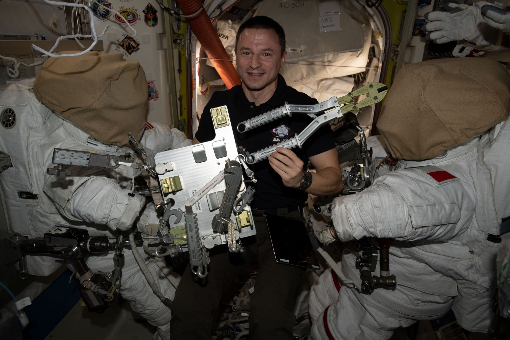 NASA astronaut Andrew Morgan checks specialized spacewalking tools designed specifically to repair the International Space Station's cosmic particle detector, the Alpha Magnetic Spectrometer (AMS). Morgan and ESA (European Space Agency) astronaut Luca Parmitano will conduct several spacewalks in November to upgrade the AMS thermal control system.