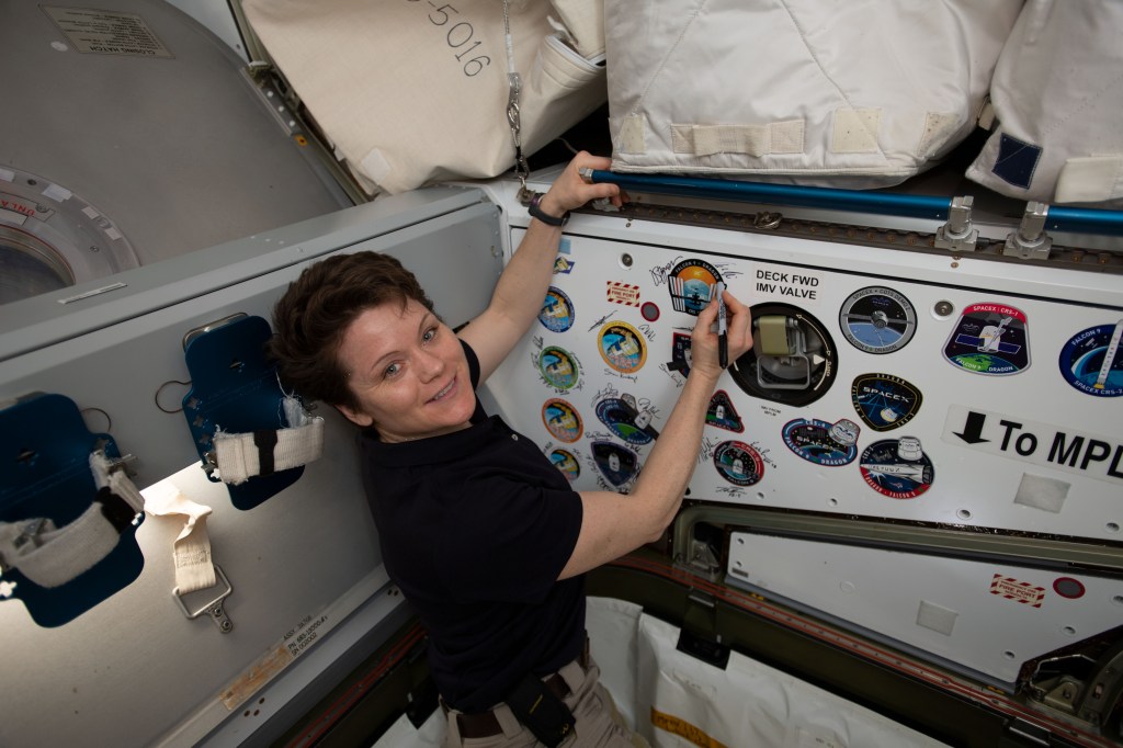 NASA astronaut Anne McClain signs the inside of the vestibule between the SpaceX Dragon cargo craft and the Harmony module. The hatch to Dragon was later closed and the resupply ship detached from Harmony before it was released from the grips of the Canadarm2 robotic arm. Dragon spent nearly a month attached to the International Space Station.