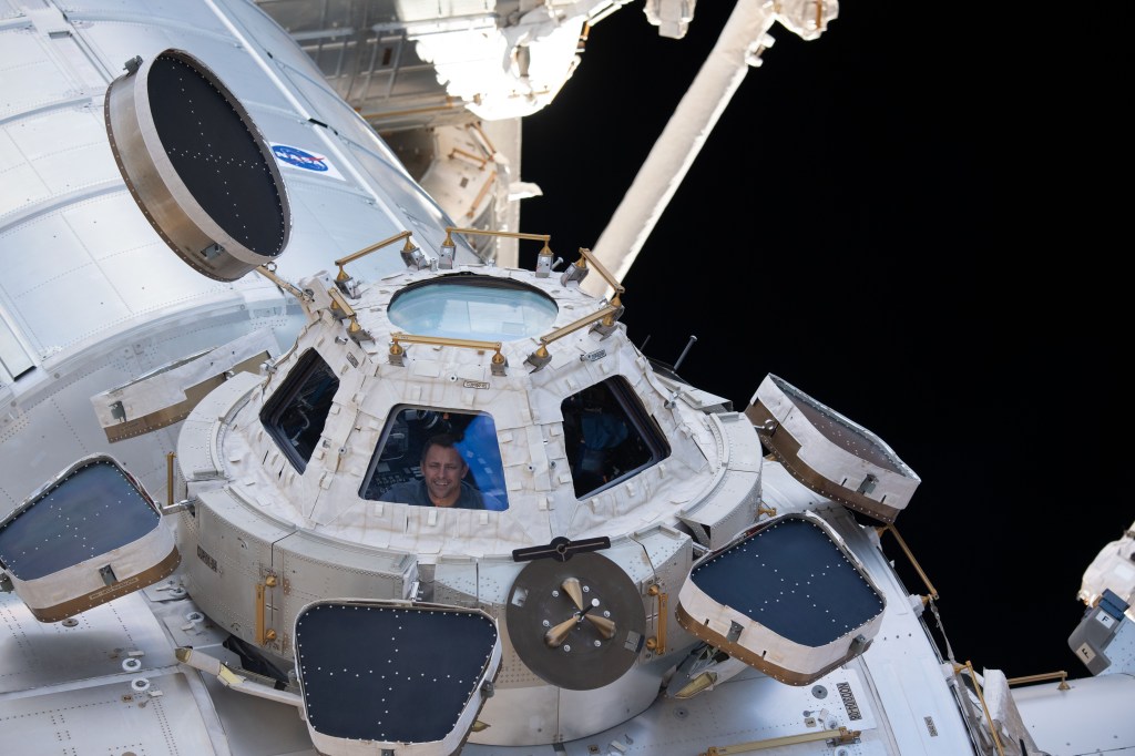 iss068e036094 (Jan. 2, 2023) --- NASA astronaut and Expedition 68 Flight Engineer Josh Cassada peers through one of the seven windows in the cupola, the International Space Station's "window to the world."