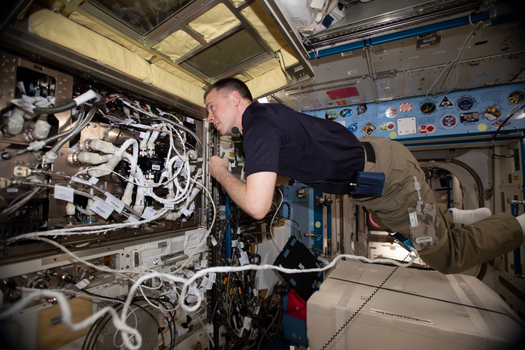NASA astronaut Nick Hague works inside the Japanese Kibo laboratory module on maintenance activities.