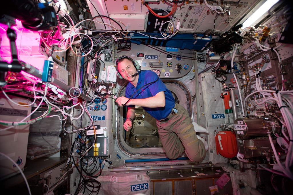 NASA astronaut Nick Hague floats inside Europe's Columbus laboratory module during a HAM radio session using the International Space Station's call sign NA1SS.