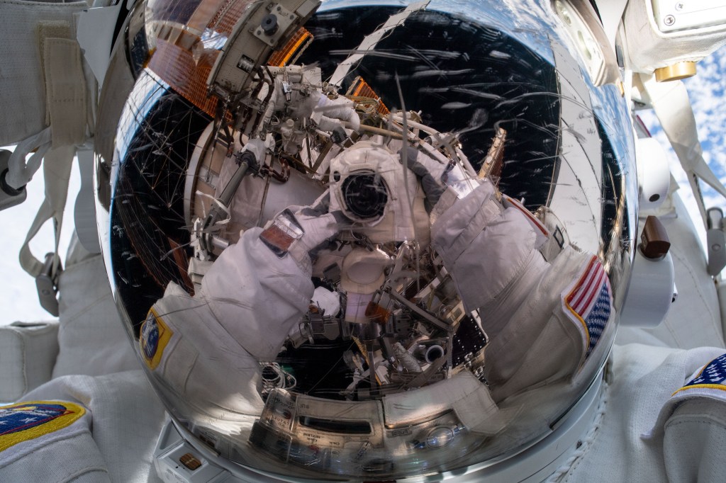 iss068e045116 (Feb. 2, 2023) --- NASA astronaut and Expedition 68 Flight Engineer Nicole Mann points the camera toward herself and takes a "space-selfie" during a six-hour and 41-minute spacewalk. She and fellow spacewalker Koichi Wakata (out of frame) of the Japan Aerospace Exploration Agency (JAXA) installed a modification kit on the International Space Station's starboard truss structure preparing the orbital lab for its next roll-out solar array.
