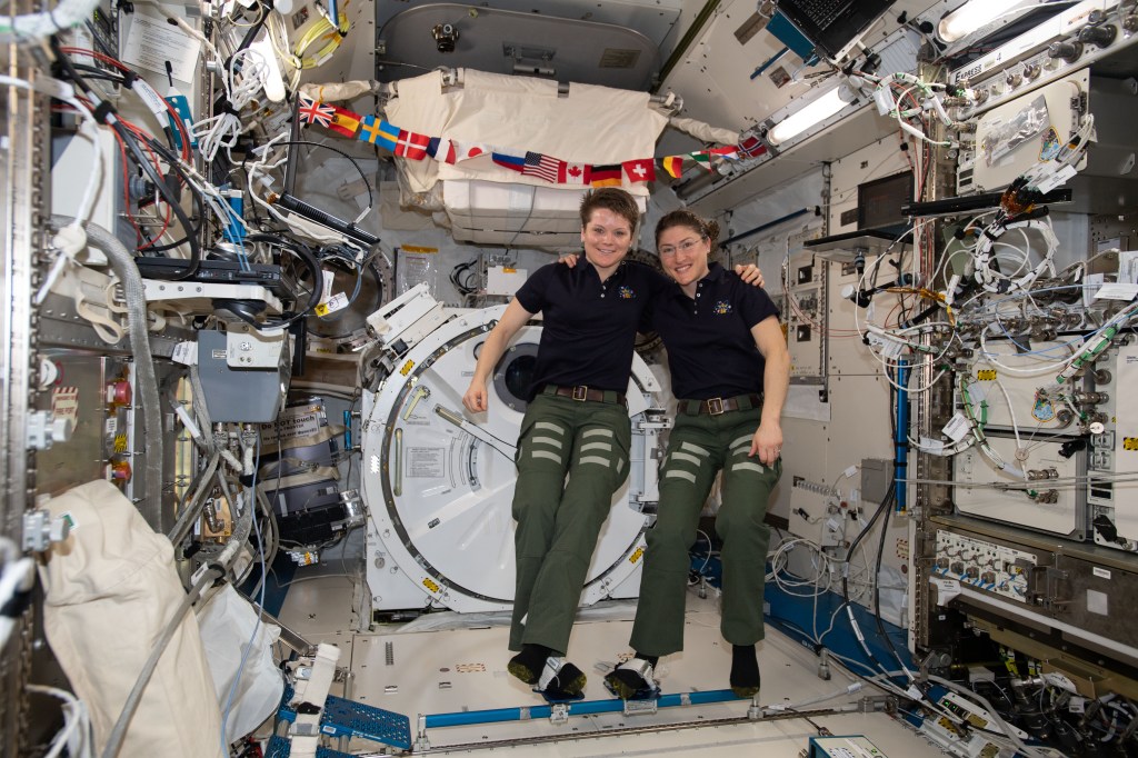 NASA astronauts (from left) Anne McClain and Christina Koch pose for a portrait inside the Kibo laboratory module from the Japan Aerospace Exploration Agency (JAXA). Both Expedition 59 flight engineers are members of NASA's 2013 class of astronauts.