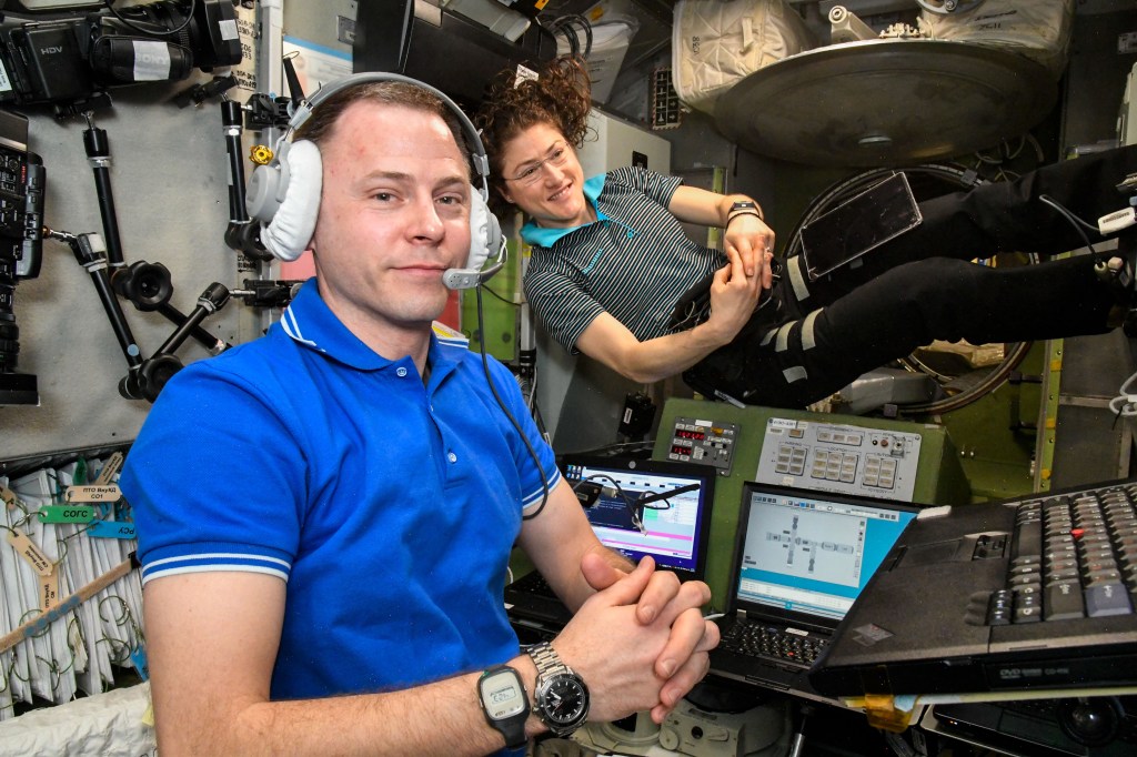 NASA astronauts Nick Hague and Christina Koch practice an emergency simulation inside the International Space Station's Zvezda service module. The duo, along with cosmonaut Alexey Ovchinin (out of frame), practiced emergency procedures for quickly entering their Soyuz lifeboat, undocking from the station and descending to Earth.