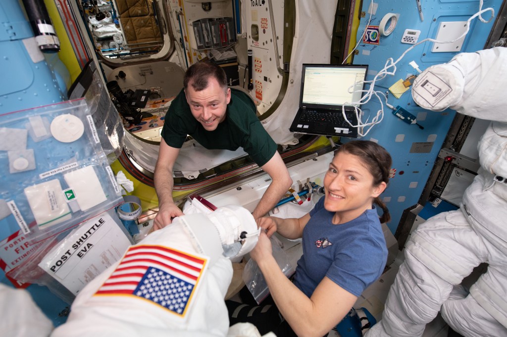 NASA astronauts Nick Hague (left) and Christina Koch work on U.S. spacesuits in the Quest airlock before the Expedition 59 crew members would begin a series of spacewalks to upgrade power systems on the International Space Station. Quest is divided into two parts. The equipment lock is where spacewalkers configure their tools and suit up in their U.S. spacesuits. The crew lock is the unit that is depressurized and repressurized and contains the hatch where the spacewalkers exit into the vacuum of space.