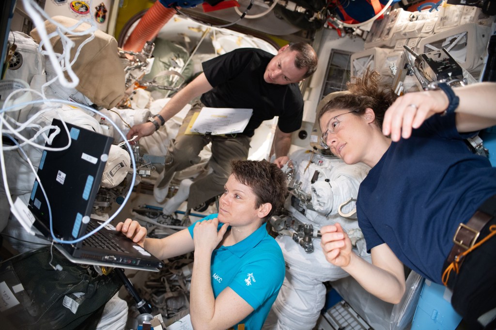NASA astronauts Nick Hague, Anne McClain and Christina Koch (right) work on U.S. spacesuit maintenance in the Quest airlock of the International Space Station.
