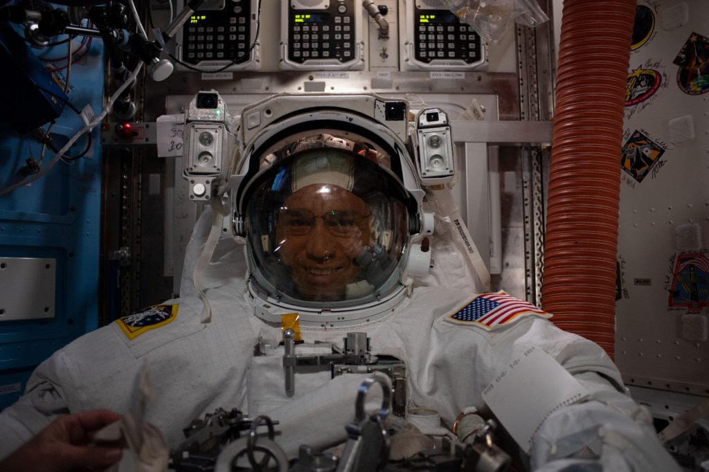 iss068e022427 (Nov. 15, 2022) --- NASA astronaut and Expedition 68 Flight Engineer Frank Rubio is pictured suited up in his Extravehicular Mobility Unity (EMU), or spacesuit, in the International Space Station's Quest airlock. He and fellow NASA astronaut Josh Cassada (out of frame) conducted a seven-hour and 11-minute a spacewalk to ready the orbiting lab's starboard truss structure for future rollout solar array installation work. Credit: Josh Cassada/NASA