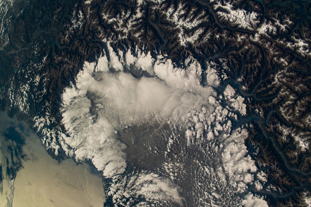 iss068e012218 (Oct. 5, 2022) --- The Swiss Alps surround Northern Italy's cloud-covered Po Valley region in this photograph taken from the International Space Station as it orbited 264 miles above. Credit: ESA/Samantha Cristoforetti