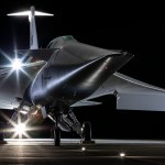 NASA's X-59 airplane sits on the ground with lights shining on it.