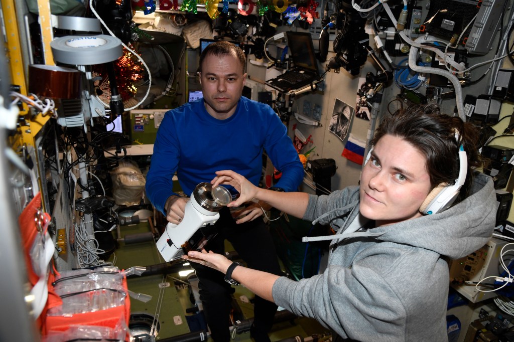 iss068e054601 (Jan. 3, 2023) --- Expedition 68 Flight Engineers (from left to right) Dmitri Petelin and Anna Kikina work inside the International Space Station's Zvezda service module collecting and analyzing microbe samples.