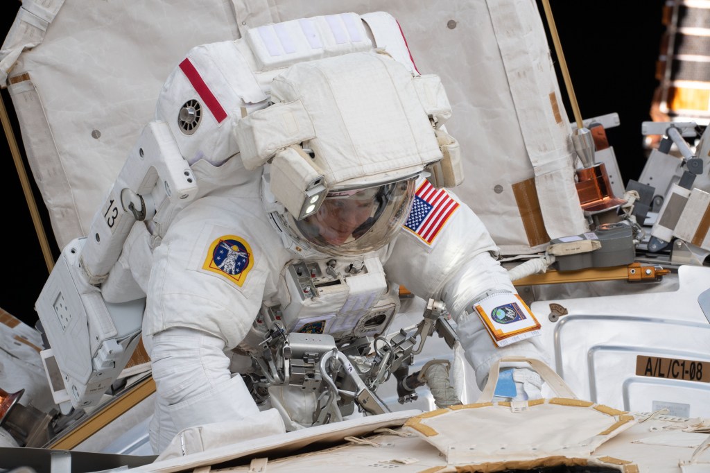 NASA astronaut Anne McClain works outside the U.S. Quest airlock where she exited shortly after beginning a six-hour, 39-minute spacewalk to upgrade the International Space Station's power storage capacity.