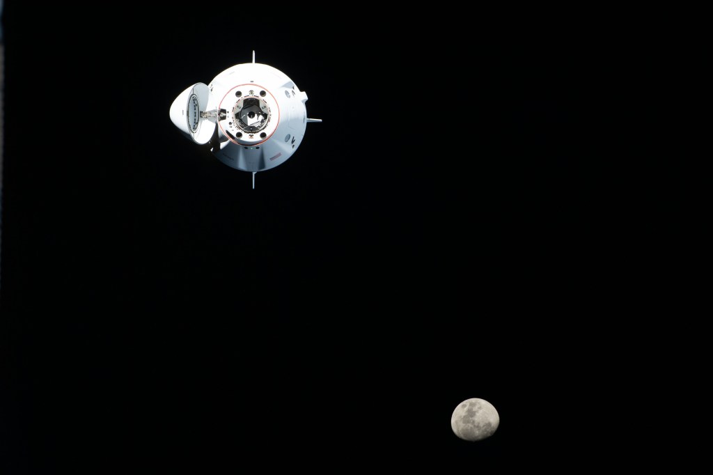 iss068e014220 (Oct. 6, 2022) --- The SpaceX Dragon Endurance crew ship, carrying four Crew-5 members, approaches the International Space Station with the waxing gibbous Moon pictured in the background. Credit: NASA/Kjell Lindgren