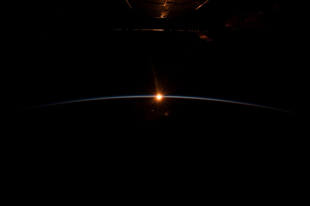 iss068e038496 (Dec. 31, 2022) --- The first rays of an orbital sunrise begin to illuminate the Earth's atmosphere and reflect off the Earth-facing portion of the International Space Station as it orbited 263 miles above the northern Pacific Ocean south of Alaska's Aleutian Island's.
