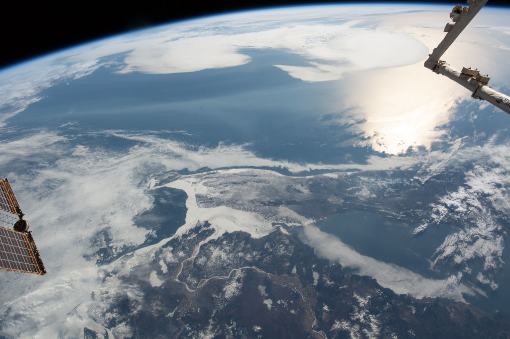 The International Space station was flying 258 miles above of China's eastern border with Russia when an Expedition 59 crewmember photographed the frozen Strait of Tartary. The strait separates the Russian island of Sakhalin from the Asian continent. The sun's glint beams off the Northern Pacific coast of Sakhalin.