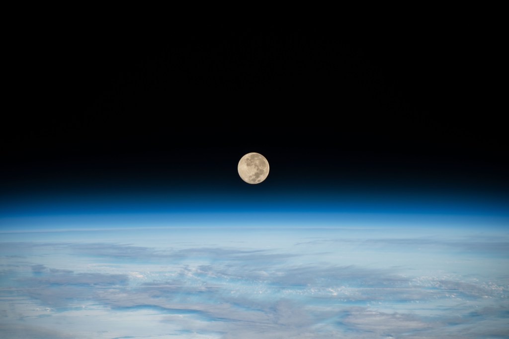 iss068e027828 (Dec. 8, 2022) --- The Full Moon is pictured setting below Earth's horizon from the International Space Station as it orbited 269 miles above the southern Indian Ocean. At the time of this photograph the Orion vehicle on the Artemis I mission was about 207,200 miles from Earth and 180,400 miles from the Moon, cruising at 1,415 mph.