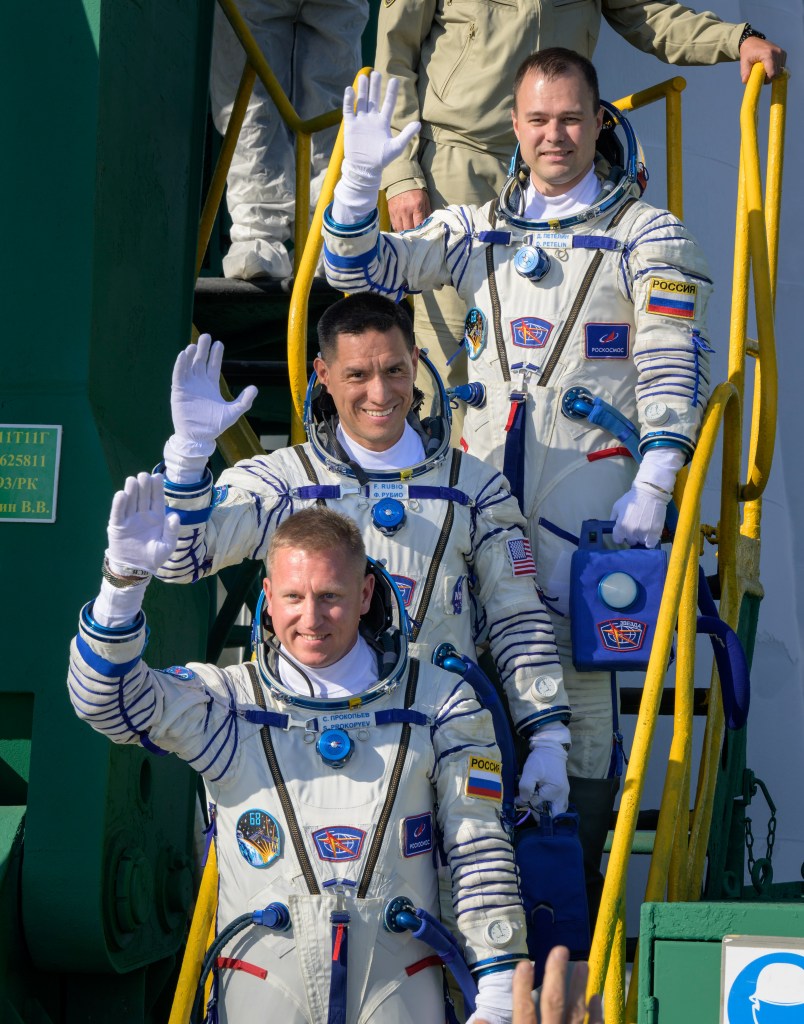 nhq2022092100018 (Sept. 21, 2022) --- Expedition 68 crew members Dmitri Petelin of Roscosmos, top, Frank Rubio of NASA, and Sergey Prokopyev of Roscosmos, bottom, wave farewell prior to boarding the Soyuz MS-22 spacecraft for launch, Wednesday, Sept. 21, 2022, at the Baikonur Cosmodrome in Kazakhstan. Rubio, Prokopyev and Petelin, will launch onboard the Soyuz rocket from the Baikonur Cosmodrome for a mission on the International Space Station. Photo Credit: (NASA/Bill Ingalls)