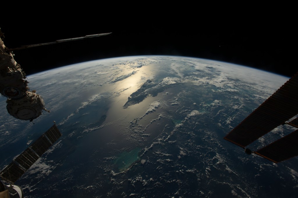 iss068e023212 (Nov. 20, 2022) --- The sun's glint beams across the Caribbean Sea and the Atlantic Ocean highlighting Cuba and Haiti in this photograph from the International Space Station as it orbited 258 miles above.