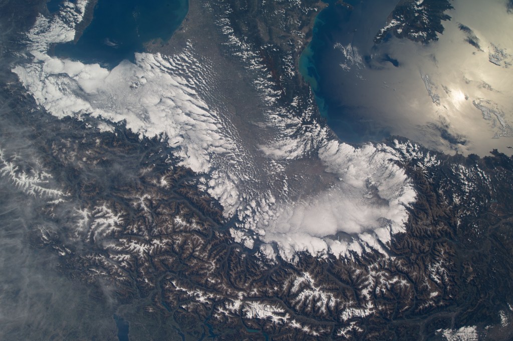 iss068e008924 (Oct. 5, 2022) --- The Swiss Alps surround Northern Italy's cloud-covered Po Valley region in this photograph taken from the International Space Station as it orbited 264 miles above. Credit: ESA/Samantha Cristoforetti