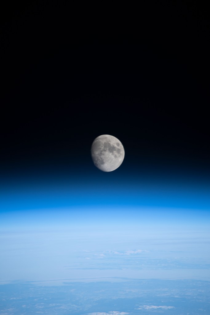 iss068e026677 (Dec. 4, 2022) --- The waxing gibbous Moon is pictured above Earth's horizon from the International Space Station as it orbited 261 miles over the northern Pacific Ocean. At the time of this photograph the Orion vehicle on the Artemis I mission was almost 24,000 miles away from the Moon and approximately 222,200 miles from Earth traveling at a speed of 3,076 miles per hour.