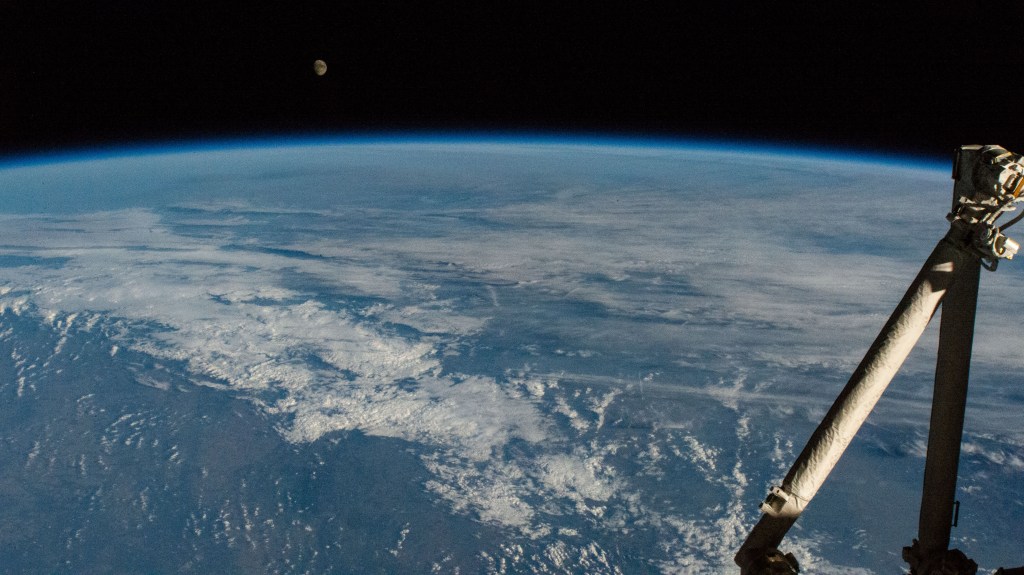 iss068e012259 (Oct. 6, 2022) --- The waxing gibbous Moon is pictured above the Earth's horizon as the International Space Station orbited 264 miles above the Netherlands. In the right foreground, is the Japanese robotic arm that supports payload operations outside the Kibo laboratory module.