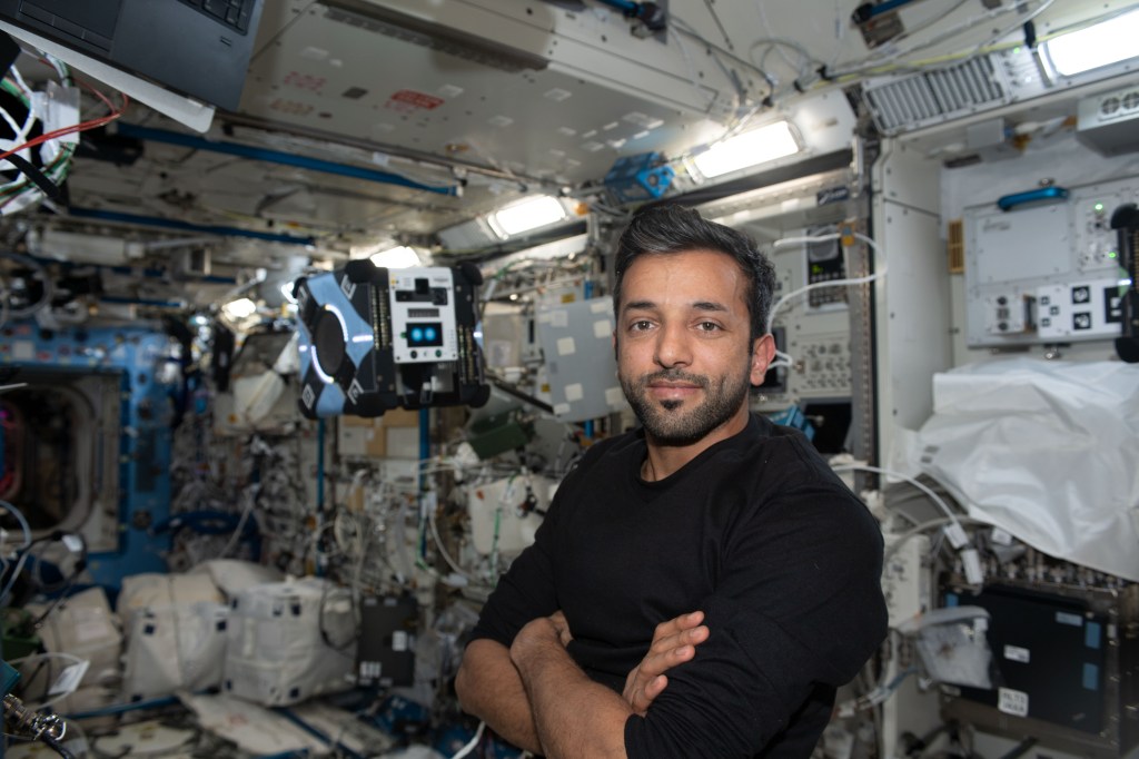 iss068e076362 (March 24, 2023) --- UAE (United Arab Emirates) astronaut and Expedition 68 Flight Engineer Sultan Alneyadi poses with a free-flying AstroBee robotic helper inside the International Space Station's Kibo laboratory module. The AstroBee is a cube-shaped, toaster-sized robotic device that is being tested for its ability to assist astronauts with routine chores, and give ground controllers additional eyes and ears on the space station.
