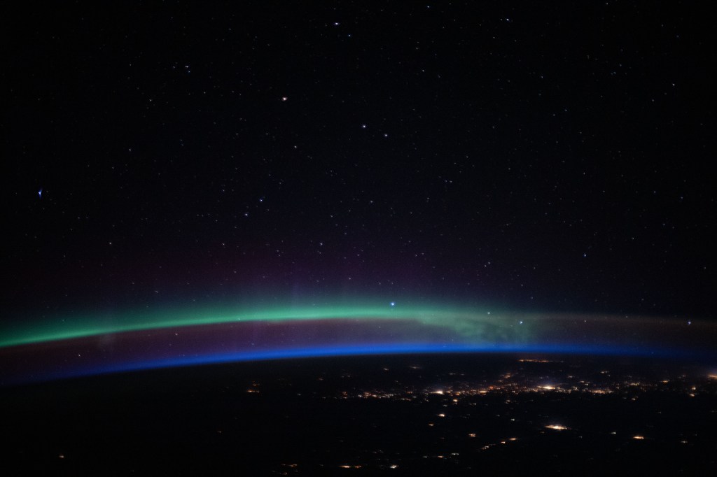 iss062e098273 (March 16, 2020) --- An aurora, above the city lights and a beneath a starry sky, fades into an orbital sunrise as the International Space Station orbited 263 miles above the Pacific Ocean off the coast of North America.