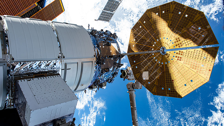 The Cygnus space freighter is pictured attached to the space station as the Canadarm2 robotic arm prepares to grapple the cargo craft.