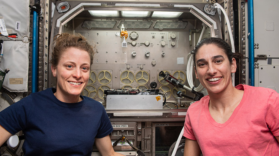 Astronauts (from left) Loral O'Hara and Jasmin Moghbeli are pictured in front of the Microgravity Science Glovebox, a biology and physics research facilty.