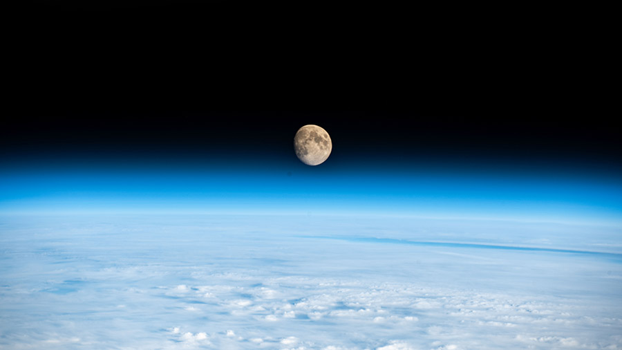 The waxing gibbous Moon is pictured above the Earth's horizon in this photograph from the space station as it orbited above a cloudy Western Europe.