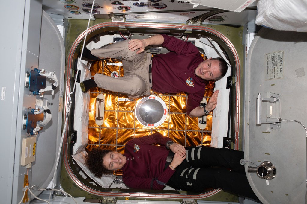 iss062e087495 (March 9, 2020) --- Expedition 62 Flight Engineers Jessica Meir and Andrew Morgan are pictured in front of the hatch to the Space Dragon resupply ship shortly after it was attached to the Harmony module for a month-long cargo mission.